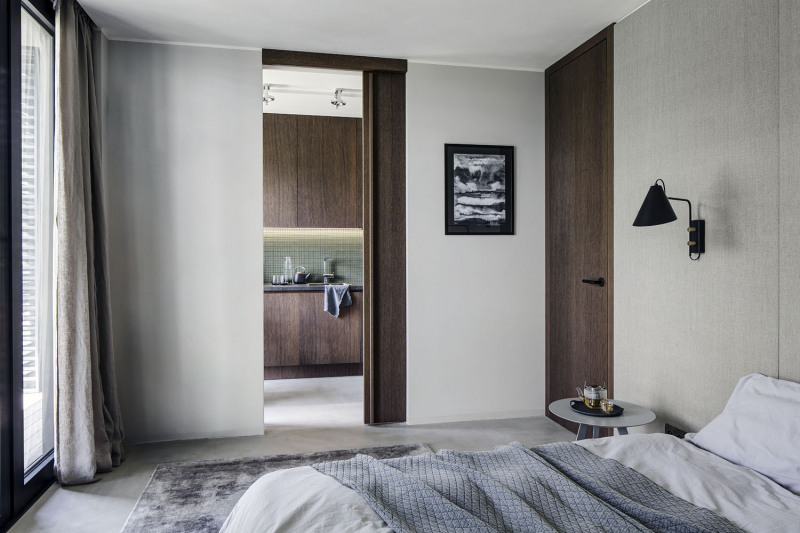 Vestavěné dveře a nábytek byly vyrobeny na zakázku podle návrhu architektky. Design je minimalistický – skříňky převážně bez úchytek, dveře bezfalcové, hlavní ozdobou je krásná struktura tmavé olejované dubové dýhy. Černé doplňky jsou jako pomyslná třešnička na elegantním dortu