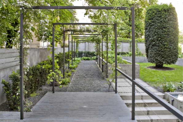 Z počátku zahradě dominovaly technické konstrukce, které ale postupem času pohltila vegetace. Zahrada se snaží návštěvníkovi nabídnout co nejužší kontakt s rostlinami, které se dostávají do jeho těsné blízkosti. Rostliny jsou v různých výškových úrovních všude kolem, u nohou, nad hlavou díky pergolám, na dotek díky vyvýšeným záhonům. Tuto zelenou scénu si mohou obyvatelé domu zabydlet dle svých aktuálních potřeb skládacími stolky a židlemi, které jsou uloženy ve skládku pod terasami